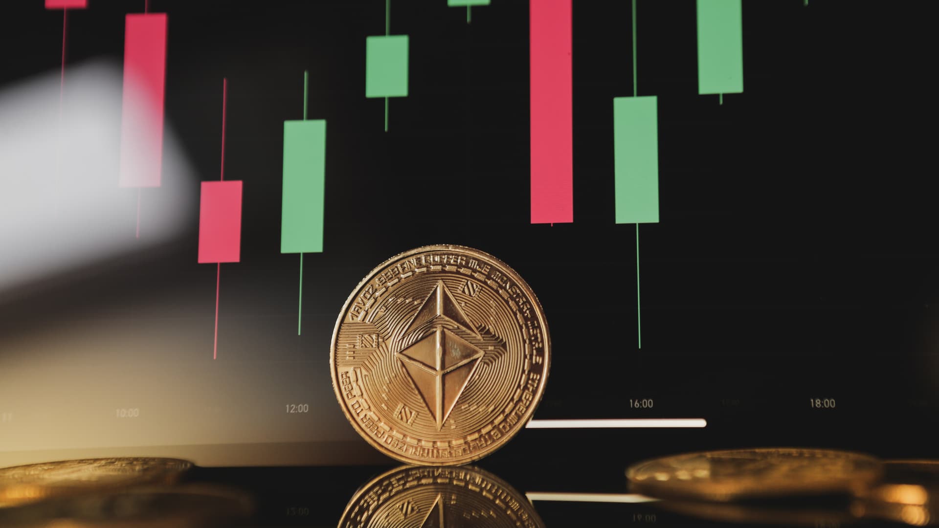 Gold Ethereum crypto currency on background of chart diagram.