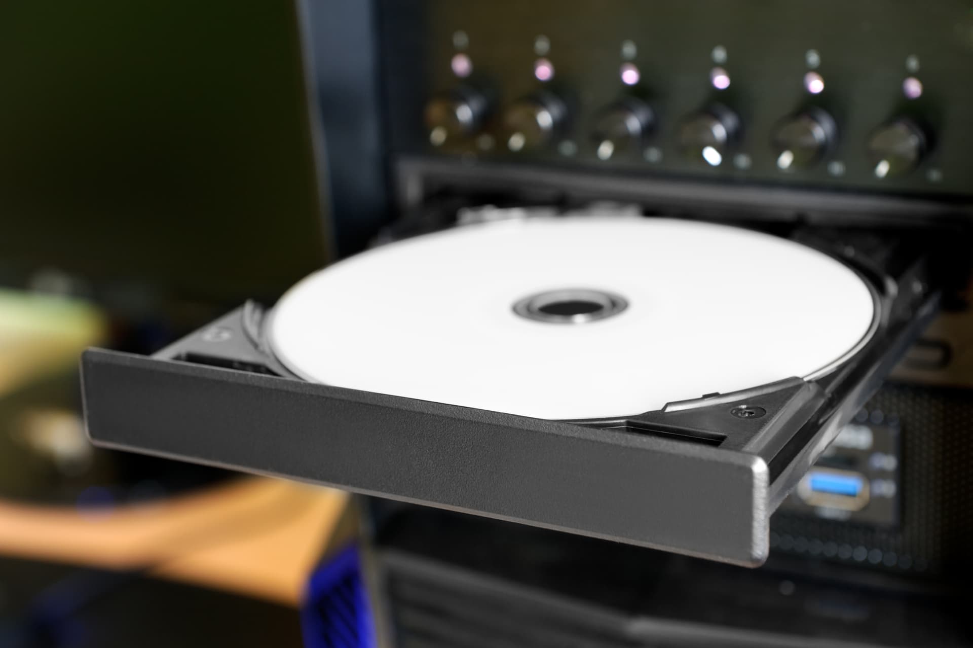 Desktop PC with open disc tray. White printable DVD disc inside.