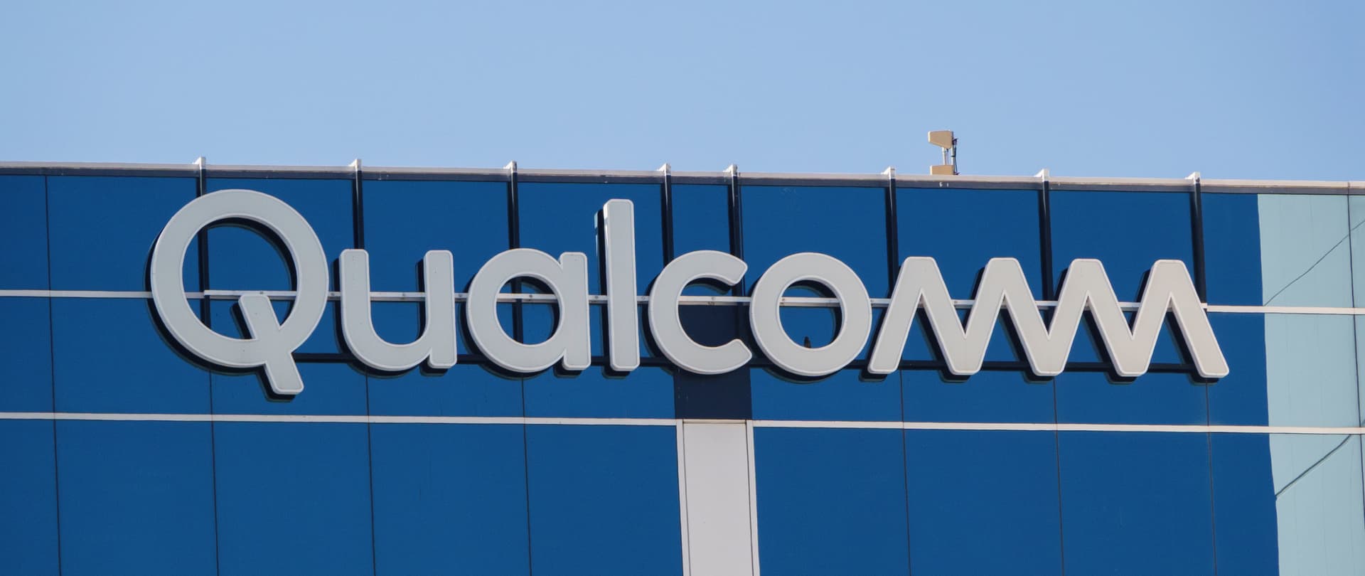 A Qualcomm logo is displayed on a building on their campus