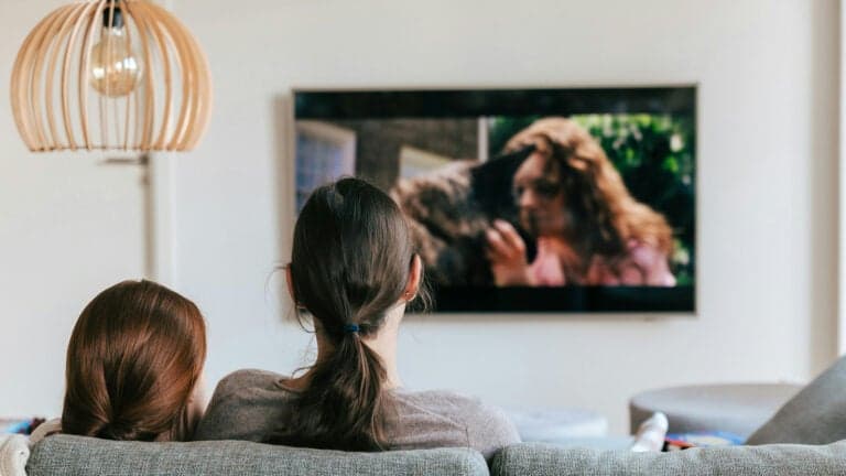 Photo of a woman and her daughter watching television.