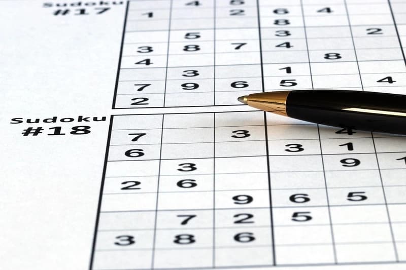 Sudoku board with a pen on top of it